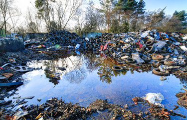 Trash (rubbish) sits in piles next to pooling water at the abandoned Furber's Scrapyard in...