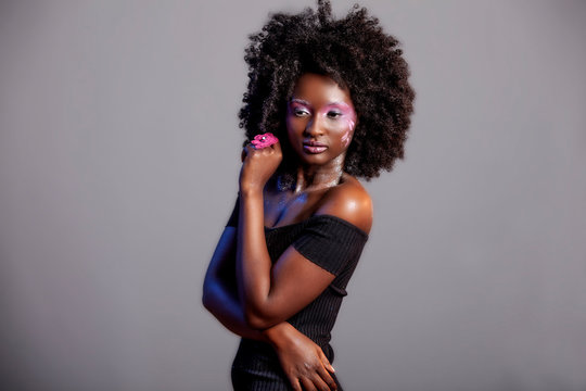 Afro and Flower beauty with big black hair smooth dark skin  does stunning poses for studio photography shoot 