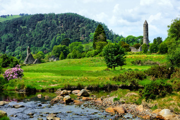 View of the historic Glendalough monastic site with ancient round tower and church in Wicklow...