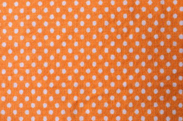 Texture of orange polka dot fabric, closeup