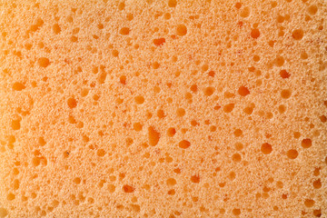 Texture of orange sponge as background, closeup