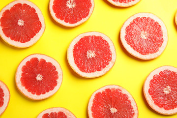 Naklejka na ściany i meble Fresh sliced ripe grapefruits on color background, flat lay