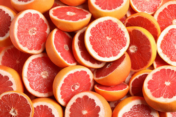 Many sliced fresh grapefruits as background, top view - Powered by Adobe