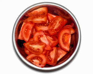 Tomatoes in a steel bowl on white background. Top view.