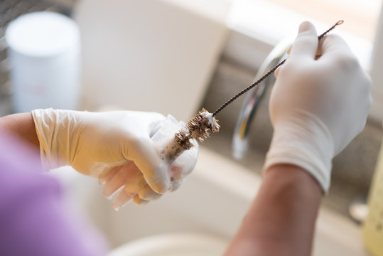 Close Up Worker Hand Washing And Brushing Test Tube In Laboratory Room.Scientist Hand Holding And Cleaning Blood Test Tube In Biological Lab Room. 