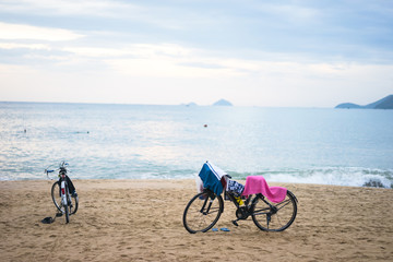 Fototapeta premium bikes parked in the sand dune along the beach on a bright sunny summer day at sunset