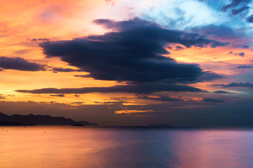 Naklejka na ściany i meble sunrise with a dramatic cloudy sky over the beach