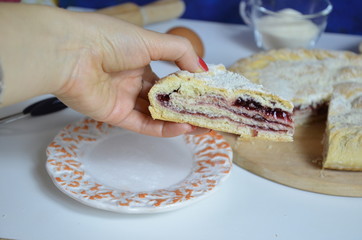 Homemade pie with cherry berries, cup of tea and fork on white wooden table. with ingredients for cooking, cinnamon, anise, icing sugar, topping. homemade baking. copy space. Top view.