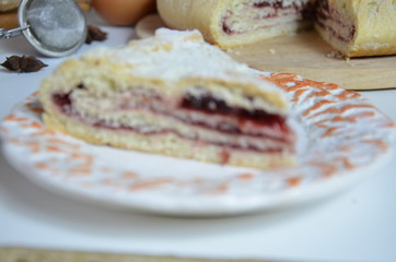 Homemade pie with cherry berries, cup of tea and fork on white wooden table. with ingredients for cooking, cinnamon, anise, icing sugar, topping. homemade baking. copy space. Top view.