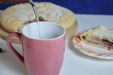 Homemade pie with cherry berries, cup of tea and fork on white wooden table. with ingredients for cooking, cinnamon, anise, icing sugar, topping. homemade baking. copy space. Top view.
