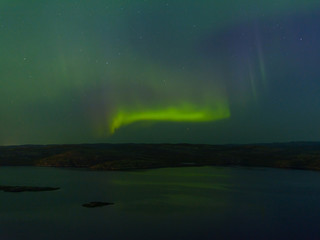 Green northern lights over the water, reflection, aurora.