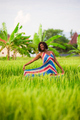 lifestyle portrait of young attractive and happy black African American woman posing cheerful having fun outdoors at beautiful rice field background enjoying holidays trip