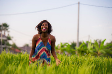 lifestyle portrait of young attractive and happy black afro American woman posing cheerful having fun outdoors at beautiful rice field background enjoying holidays trip