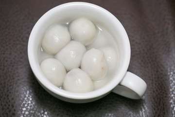 Flat lay Chinese food `tang yuan` glutinous rice ball sweet hot soup on kitchen table top. - Image