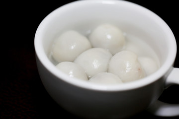 Flat lay Chinese food "tang yuan" glutinous rice ball sweet hot soup on kitchen table top. - Image