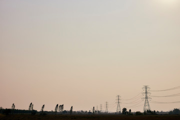 Silhouette electricity post against sunset