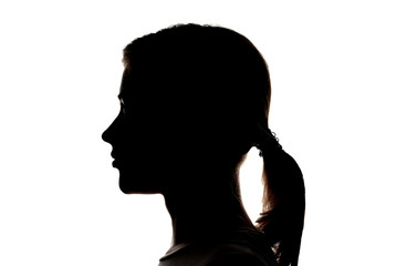Dark silhouette profile of a young girl on a white background, the concept of anonymity