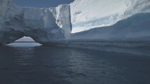 Iceberg Arch Antarctic Ocean Water Seascape. Hole in Massive Ice Wall Floating in Arctic Glacier Sea at Falkland. Massive Melting Ice Bridge Concept Landscape Shot Footage 4K (UHD)