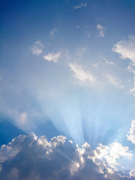 Clouds in blue sky with rays of light
