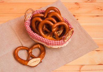Fresh soft pretzels in wicker basket and near. Selective focus.