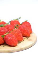 red strawberry on wooden plate