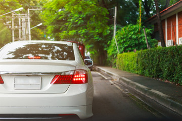 luxury white car driving on green city road