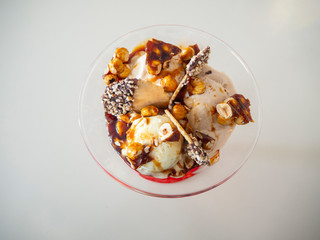 Cup of vanilla ice cream with cream, crunchy, hazelnuts and biscuits