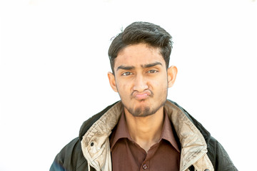 Obraz premium Portrait shot of young teenager beard wearing a maroon colored shirt and a black colored jacket expressing doubtfulness on his face isolated on white.