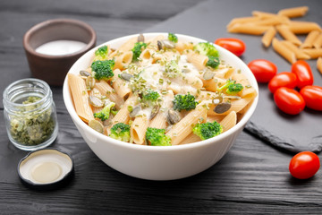 Pasta with broccoli, green onion and pumpkin seeds, sprinkled with white sauce