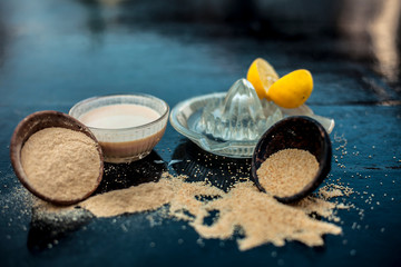 Obraz na płótnie Canvas Key ingredients to make poppy seeds cake with lemon juice or muffins or dough nuts on wooden surface i.e. Poppy seeds and its powder and some lemon juice in glass juicer.