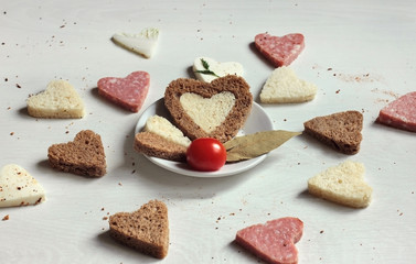 Delicious composition - sandwiches and bread in the form of hearts on the table