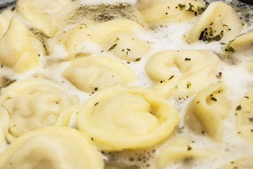 meat dumplings are boiled in a pot of boiling water