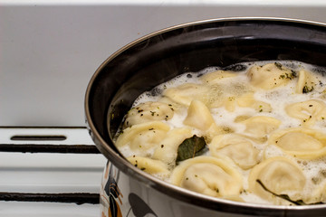 meat dumplings are boiled in a pot of boiling water