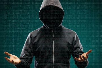 Dangerous hacker over abstract digital background with binary code. Obscured dark face in mask and hood. Data thief, internet attack, darknet fraud, virtual reality and cyber security.
