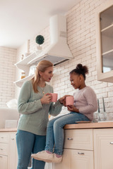 Blonde-haired mother drinking tea with daughter before work