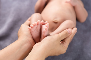 Parent holding feet of newborn baby in the hands