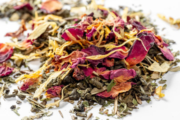 Green tea with dried flower petals and pieces of citrus on white background. Dried tea for welding. Diet and healthy drink
