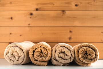 Rolled up bath towels on wooden background.