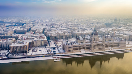 Budapest, Hungary - Golden sunrise over Budapest with snowy rooftops, Parliament of Hungary and St. Stephen's Basilica at background