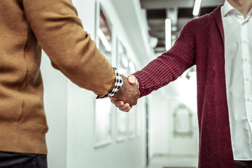 Office worker in white shirt and burgundy cardigan shaking hands