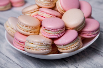 Fototapeta na wymiar Plate of fresh colorful macarons. Raspberry and strawberry pink macarons on soft pastel pink background