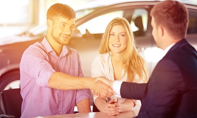 Fototapeta premium Happy family with car dealer in auto show or salon buy a car