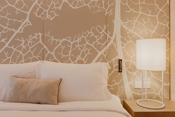 Close up fragment of bedroom with reading lamp  in modern home or hotel