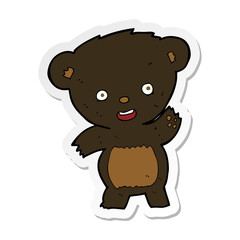 sticker of a cartoon waving black bear
