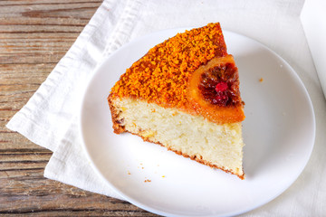 Big round semolina cake with caramelized sliced orange and berries , poured with berry syrup and sprinkled with orange zest