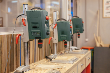 Stand with professional tools drills stand in the carpentry workshop. Concept of equipment for the carpentry