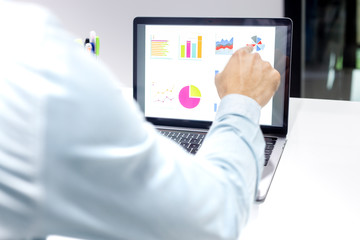 Businessman workspace laptop with coffee cup ,computer screen graphics and charts