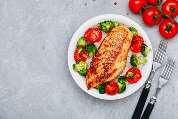 Healthy rice lunch bowl with roasted chicken, grilled tomatoes and broccoli