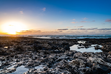 Scenic view of rocky beach  at sunset