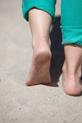 Feet of woman walking on the sand